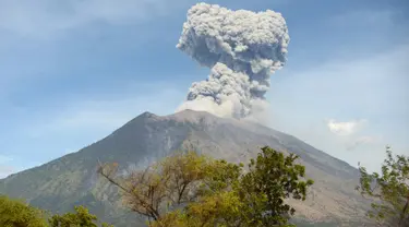 Asap bercampur abu vulkanis keluar dari kawah Gunung Agung terlihat dari desa Tulamben, Karangasem, Bali, Selasa (3/7). Pagi ini, Gunung Agung kembali meletus disertai abu vulkanik setinggi 2.000 meter di atas puncak. (AFP/SONNY TUMBELAKA)