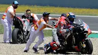 Pembalap Ducati, Andrea Dovizioso mendorong motonya seusai mengalami tabrakan pada MotoGP Spanyol 2018 di Sirkuit Jerez, Minggu (6/5). MotoGP Spanyol 2018 diwarnai drama kecelakaan Andrea Dovizioso, Jorge Lorenzo, dan Dani Pedrosa (AFP/JAVIER SORIANO)