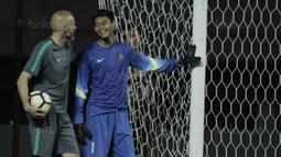 Kiper Indonesia, Satria Tama, berbincang dengan pelatih kiper Eduardo Perez Moran saat latihan jelang laga melawan Fiji di Stadion Patriot, Bekasi, Kamis, (31/8/2017). Indonesia akan menjalani laga Persahabatan melawan Fiji. (Bola.com/M. Iqbal Ichsan) 