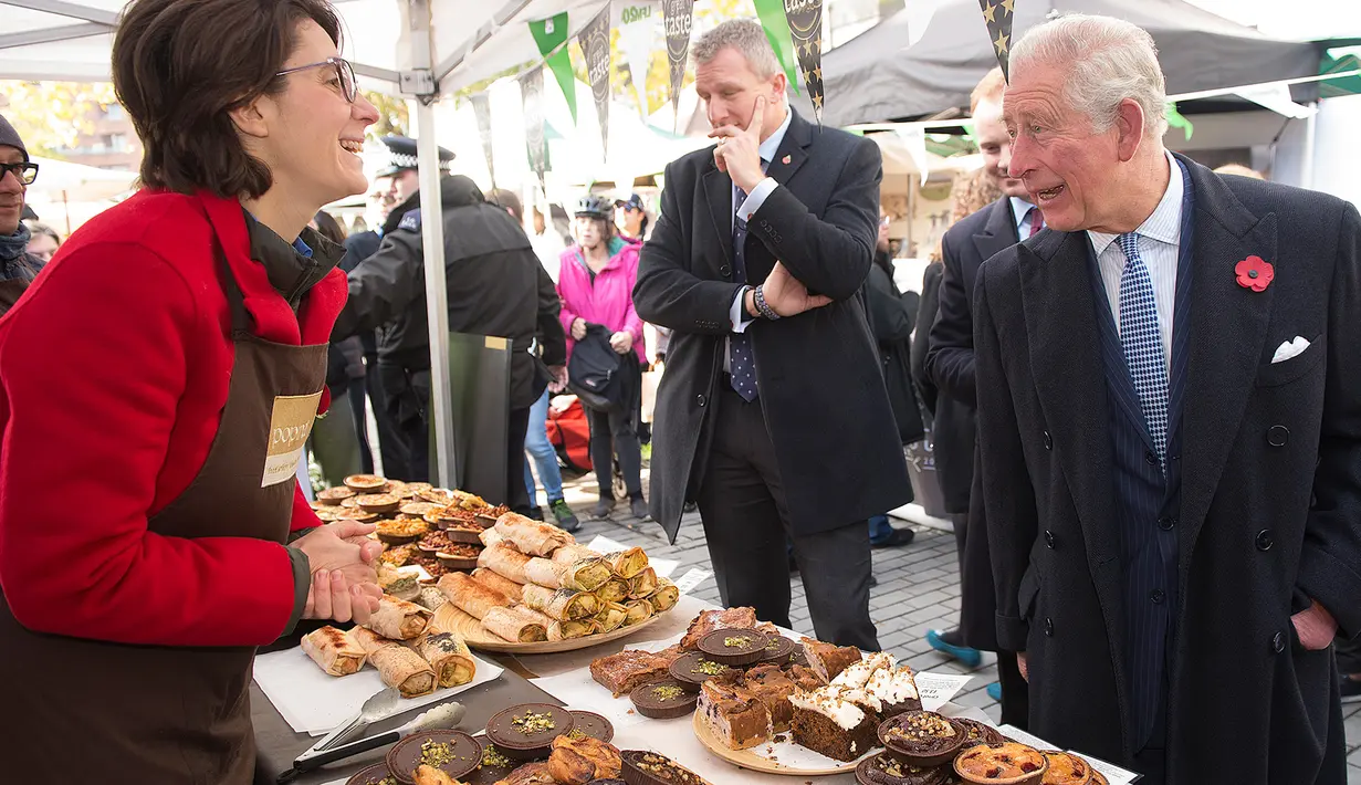 Pangeran Charles berbincang dengan pedagang ketika mengunjungi Swiss Cottage Farmers Market di London utara, Rabu (6/11/2019). Kunjungan Pangeran Charles dan Camila untuk mengucapkan selamat dan memperingati ulang tahun ke-20 pasar tersebut. (Eddie Mulholland / POOL / AFP)