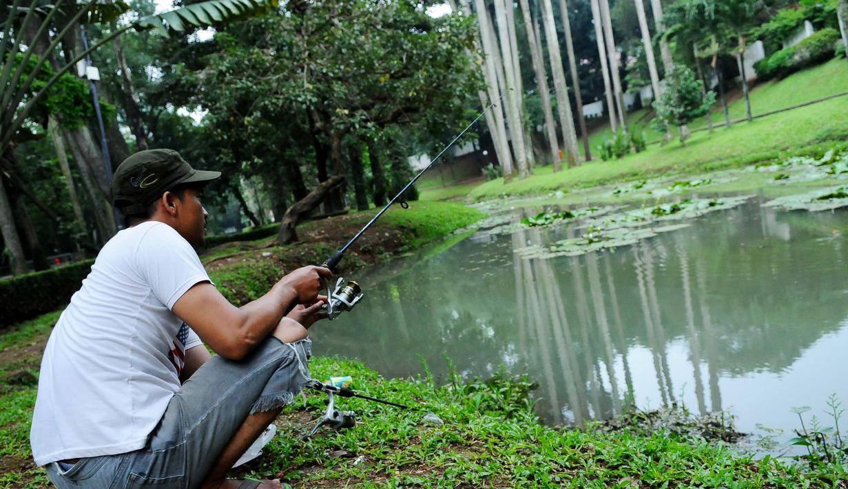 Seorang warga memanfaatkan area danau untuk memancing di Taman Langsat, Kebayoran Baru, Jakarta Selatan, Kamis (06/03/14). (Liputan6.com : Andrian Martinus Tunay)