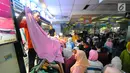 Pedagang melayani pembeli di pasar Tanah Abang, Jakarta, Minggu (26/5/2019). Jelang lebaran masyarakat mulai memadati pusat perbelanjaan untuk membeli kebutuhan saat Hari Raya Idul Fitri. (Liputan6.com/Angga Yuniar)