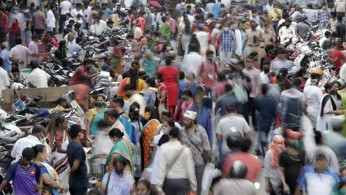 Orang-orang mengenakan masker saat mereka berbelanja menjelang Diwali atau tradisi perayaan festival cahaya di Mumbai, India, Minggu (8/11/2020). Pemerintah memperingatkan akan ada lebih dari 10 ribu kasus yang muncul setelah Festival Diwali dilakukan. (AP Photo/Rajanish Kakade)