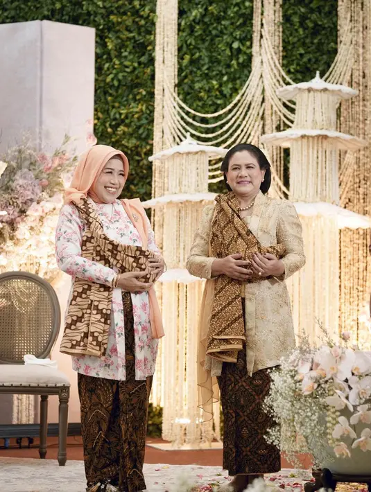 Iriana Jokowi pilih kebaya brukat gold, sedangkan Sofiatun Gudono pilih kebaya print flora. Dipadukan dengan hijab polos berwarna peach