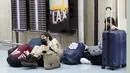 <p>Pelancong beristirahat di dekat loket tiket di Bandara Internasional Los Angeles, Senin (25/4/2022). Seminggu sebelumnya, seorang hakim federal di Florida menolak persyaratan untuk memakai masker di bandara dan selama penerbangan. Aturan itu, yang dirancang untuk membatasi penyebaran COVID-19, akan berakhir pada 3 Mei. (AP Photo/Marcio Jose Sanchez)</p>
