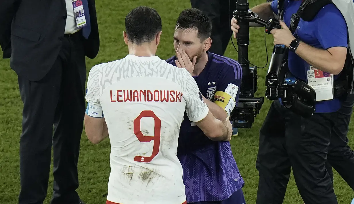 Penyerang Polandia Robert Lewandowski berinteraksi dengan penyerang Argentina Lionel Messi pada akhir matchday pamungkas Grup C Piala Dunia 2022 di 974 Stadium, Kamis (1/12/2022) dini hari WIB. Uniknya, Messi memilih tidak menjelaskan apa yang dikatakan kepada penyerang Barcelona. (AP Photo/Hassan Ammar)