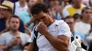 Petenis Spanyol, Rafael Nadal, bereaksi sebelum meninggalkan lapangan usai dikalahkan petenis asal Luksemburg, Giller Muller, di perempat final Wimbledon 2017, Senin (10/7). Nadal disingkirkan petenis unggulan ke-16 asal Luksemburg. (Glyn KIRK / AFP)
