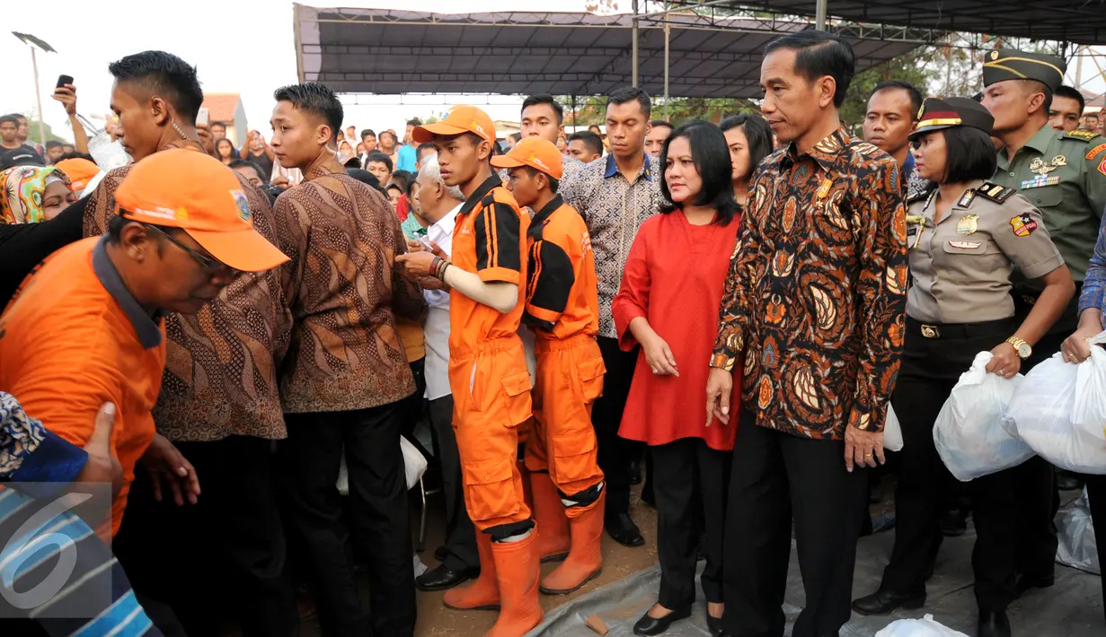 Presiden RI Joko Widodo besertaibu Iriana melihat langsung proses pembagian paket sembako kepada warga di sekitar Lapangan Bedeng, Pisangan Baru, Jakarta, Selasa (8/9/2015). (Liputan6.com/Helmi Fithriansyah)