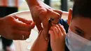 Seorang anak disuntik vaksin covid-19 CoronaVac selama kampanye vaksinasi di San Lorenzo, Paraguay, Senin (31/1/2022). Paraguay mulai memvaksinasi anak-anak berusia 5 hingga 11 tahun pada hari Senin, karena peningkatan tajam infeksi covid-19 yang didorong oleh varian omicron. (NORBERTO DUARTE / AFP)
