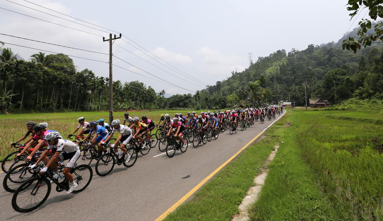 Para pebalap sepeda berlomba dalam Etape 1 Tour de Singkarak antara Painan, Kabupaten Pesisir Selatan menuju Pariaman, Sumatra Barat, Sabtu (3/10/2015). (Bola.com/Arief Bagus)