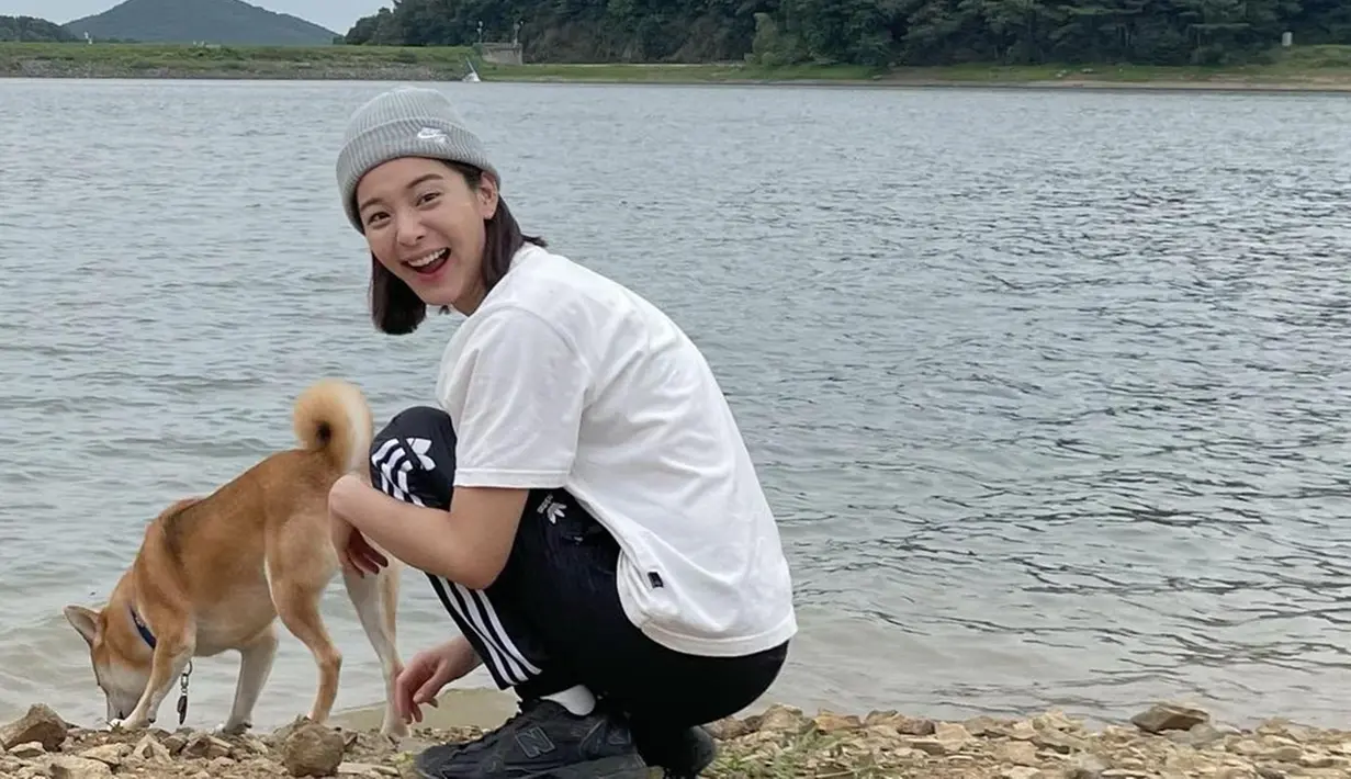 Pemeran karakter Young-seo serial Business Proposal ini tampil kasual dengan mengenakan kaus putih dan celana training hitam saat mengajak anjing peliharaannya jalan-jalan. Ia juga melengkapi penampilannya dengan beanie hat sebagai aksesori kepala. (Liputan6.com/IG/@_seorina)