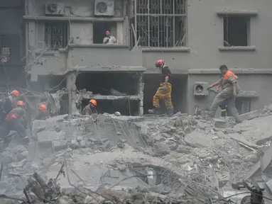 Petugas penyelamat memindahkan puing-puing bangunan yang hancur, saat mereka mencari korban di lokasi serangan udara Israel hari Kamis (10/10), di Beirut, Lebanon, Jumat, 11 Oktober 2024. (AP Photo/Hussein Malla)