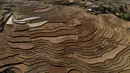 Foto udara ini menunjukkan sawah terasering di provinsi Yen Bai, Vietnam pada 29 November 2021. Terletak 300 km barat laut Hanoi, distrik Mu Cang Chai di Provinsi Yen Bai utara, sawah terasering telah menjadi destinasi wisata populer dengan turis asing dan lokal sebelum pandemi. (Nhac NGUYEN / AFP)