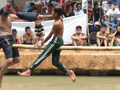 Anak-anak bermain lomba pukul bantal di sekitar Kalimalang, Jakarta, Sabtu (17/8/2019). Beragam lomba permainan digelar warga untuk menyemarakkan HUT ke-74 Republik Indonesia. (Liputan6.com/Helmi Fithriansyah)