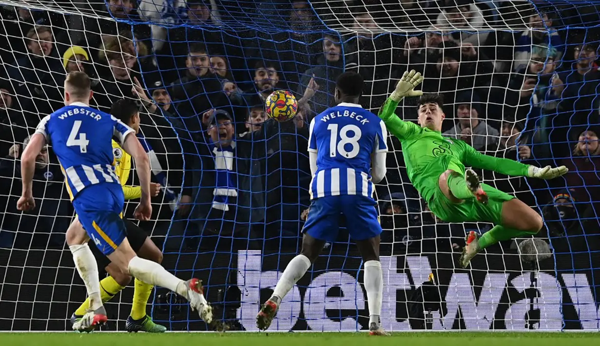 Pemain Brighton and Hove Albion Adam Webster (kiri) melakukan selebrasi usai mencetak gol ke gawang Chelsea yang dijaga kiper Kepa Arrizabalaga (kanan) pada pertandingan sepak bola Liga Inggris di American Express Community Stadium, Brighton, Inggris, 18 Januari 2022. (Glyn KIRK/AFP)
