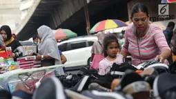 Seorang ibu bersama anaknya memilih sepatu di Pasar Asemka, Jakarta, Selasa (7/9/2019). Jelang dimulainya tahun ajaran baru, Pasar Asemka ramai dikunjungi warga untuk berbelanja keperluan sekolah. (Liputan6.com/Helmi Fithriansyah)