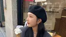 Joy saat mengenakan blazer berwarna abu sambil memakan es krim di depan sebuah toko. Penyanyi tersebut mempercantik penampilannya dengan tambahan topi. (Instagram/@_imyour_joy)