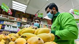 Direktur Pelaksana Pakistan Supermarket Dubai Jhanzeb Yaseen memeriksa mangga sebelum pengiriman di Dubai, Uni Emirat Arab, Kamis (2/7/2020). Supermarket tersebut mengantarkan pesanan mangga untuk minimal pesanan sekitar USD 27. (CACACE GIUSEPPE/AFP)