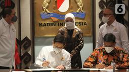 Direktur Utama BPJS Ketenagakerjaan Anggoro Eko Cahyo (kanan), Ketua Umum KADIN Indonesia Arsjad Rasjid (kiri) disaksikan Menteri Ketenagakerjaan Ida Fauziyah (tengah) menandatangani perjanjian kerja sama di Menara Kadin, Jakarta (16/03/2022). (Liputan6.com/Fery Pradolo)
