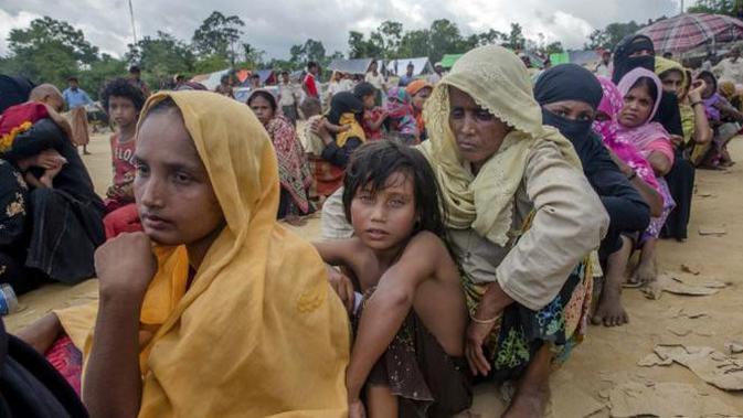 Etnis Muslim Rohingya, yang baru saja melintas perbatasan Myanmar menuju Bangladesh, sedang menunggu giliran menerima bantuan makanan dekat kamp pengungsi Balukhali (AP)
