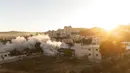 Matahari terbit saat unit tentara Israel menghancurkan rumah warga Palestina Amerika Muntasser Shalaby menggunakan ledakan terkendali, di desa Turmus Ayya, Tepi Barat, utara Ramallah (8/7/2021). (AP Photo/Nasser Nasser)