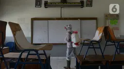 Petugas PMI menyemprotkan cairan disinfektan di Lingkungan SMP Negeri 139 Jakarta, Selasa (9/6/2020). Penyemprotan untuk mencegah penyebaran virus Corona di lingkungan sekolah itu sebagai persiapan memasuki tahun ajaran baru 2020/2021. (merdeka.com/Imam Buhori)