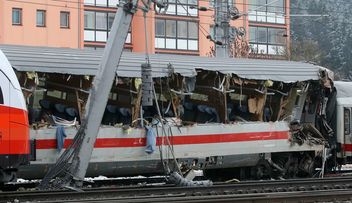 Kondisi salah satu rangkaian kereta penumpang yang terlibat tabrakan dengan kereta lainnya dekat stasiun di Niklasdorf, Austria, Senin (12/2). Bagian sisi kereta EuroCity tujuan Jerman mengalami kerusakan dan sebagian gerbong keluar rel. (AP/Ronald Zak)