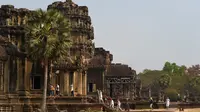 Sejumlah wisatawan berjalan di Candi Angkor Wat, Provinsi Siem Reap, Kamboja, Kamis (5/3/2020). Menurut World Travel and Tourism Council, wabah virus corona (COVID-19) membuat sektor pariwisata dunia kehilangan USD 22 miliar. (TANG CHHIN Sothy/AFP)