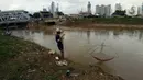 Warga mencari ikan dengan menggunakan jala di Banjir Kanal Barat, Tanah abang, Jakarta, Sabtu (4/1/2020). Debit air yang mulai surut di aliran tersebut dimanfaatkan warga untuk mencari ikan. (Liputan6.com/Angga Yuniar)
