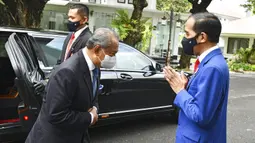 Presiden Indonesia Joko Widodo (kanan) menyapa Perdana Menteri Malaysia Muhyiddin Yassin saat bertemu di Istana Merdeka, Jakarta, Jumat (5/2/2021). Penyambutan dilakukan sesuai dengan protokol kesehatan pencegahan COVID-19. (Agus Suparto, Indonesian President Palace via AP)