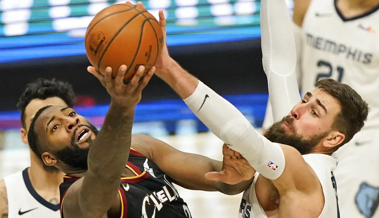 Pebasket Memphis Grizzlies, Jonas Valanciunas, berebut bola dengan pebasket Cleveland Cavaliers, Andre Drummond, pada laga NBA, Senin (11/1/2021). Grizzlies menang dengan skor 101-91. (AP/Tony Dejak)