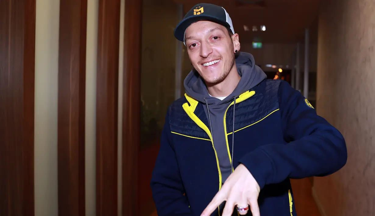 Gelandang Jerman, Mesut Ozil tersenyum saat kedatangannya di Bandara Ataturk di Istanbul (18/1/2021). Ozil akhirnya meninggalkan Arsenal dan bergabung dengan klub asal Turki, Fenerbahce. (AFP/Fenerbahce.Org)