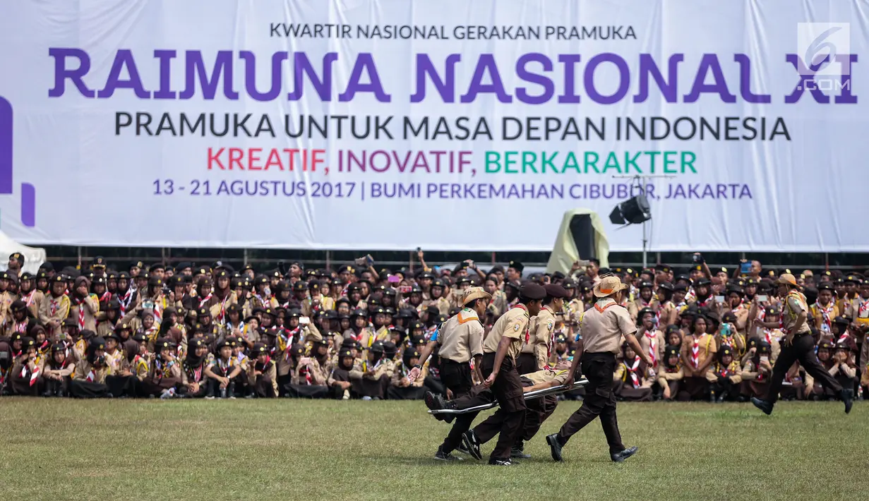 Sejumlah peserta beraksi dalam pembukaan Raimuna Nasional XI di Bumi Perkemahan Cibubur, Jakarta, Senin (14/8). Acara ini diikuti 15.000 Pramuka usia 16-25 tahun dari 34 provinsi dan 514 kota/kabupaten dari seluruh Indonesia. (Liputan6.com/Faizal Fanani)