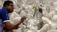 Seorang perajin mengerjakan pembuatan patung Dewa Ganesha di sebuah bengkel di Mumbai, India, 24 Agustus 2021. Pembuatan patung dewa Hindu berkepala gajah tersebut dilakukan jelang Festival Ganesh Chaturthi. (SUJIT JAISWAL/AFP)