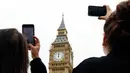 Pengunjung menggunakan ponsel merekam dentang Big Ben untuk terakhir kalinya di Elizabeth Tower, London, Senin (21/8). Menara jam itu berhenti berdentang hingga empat tahun mendatang guna renovasi besar-besaran di Gedung Parlemen (AP Photo/Frank Augstein)