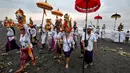 Upacara ini melibatkan prosesi orang-orang yang mengenakan pakaian tradisional Bali, membawa berbagai persembahan dan benda-benda suci. (Sonny TUMBELAKA/AFP)