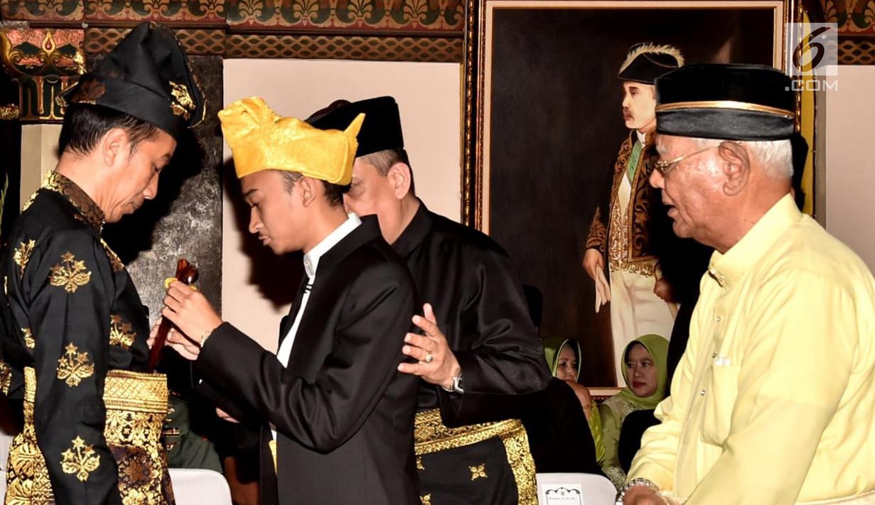 Presiden Joko Widodo menerima penyematan pin dan keris dari Sultan Deli, Tuanku Mahmud Lamantjiji Perkasa Alam saat menerima gelar Tuanku Sri Indera Utama Junjungan Negeri dari Kesultanan Deli di Istana Maimoon, Minggu (6/10). (Liputan6.com/HO/Biropers)