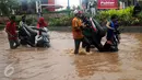 Warga membantu mendorong motor yang mogok saat berusaha menerobos banjir di Jalan Raya Kalimalang, Caman, Bekasi, Senin (20/2). Banjir setinggi 80 cm itu menyebabkan jalur dari arah Jakarta menuju Kota Bekasi tersendat. (Liputan6.com/Gempur M Surya)