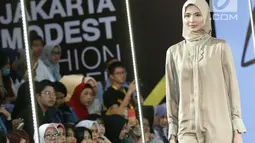 Model berjalan di atas catwalk mengenakan busana L.tru X Fenita Arie dalam ajang Jakarta Modest  Fashion Week, di Gandaria City, Jakarta, Jumat, (27/7). (Kapanlagi.com/Agus Apriyanto)