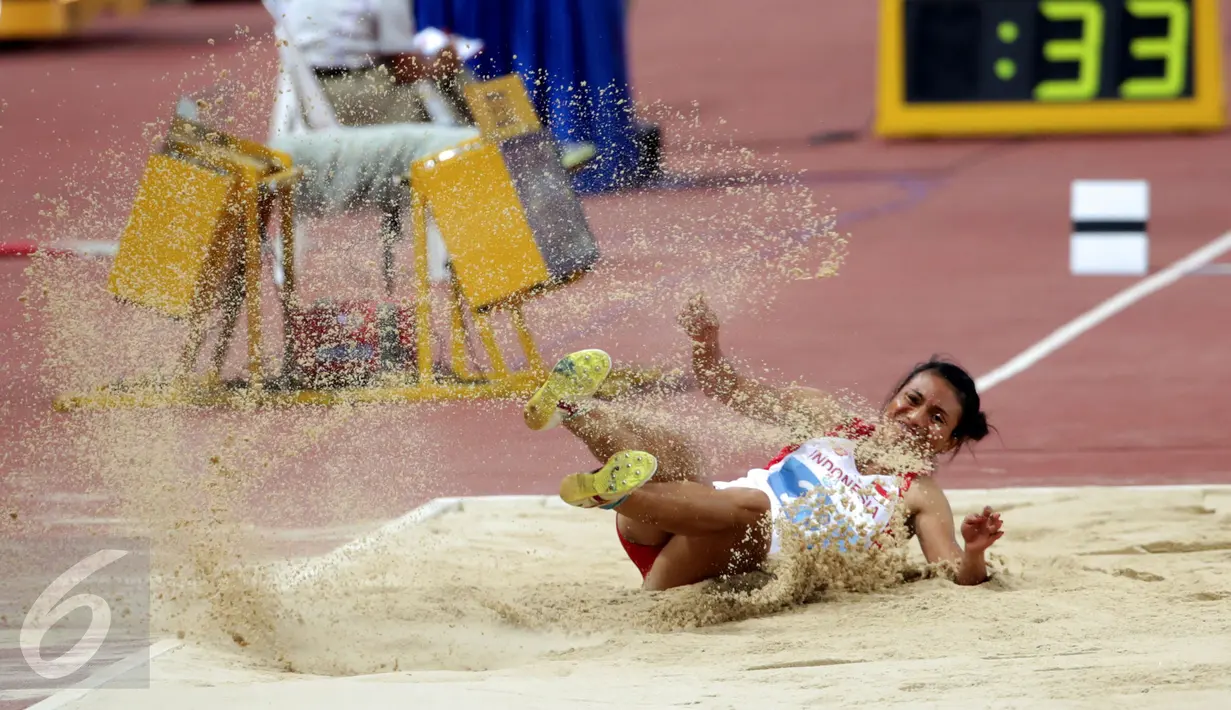Atlet putri Indonesia, Maria Londa saat mendarat usai melakukan lompatan di nomor lompat jangkit di National Stadium, Singapura, Kamis (11/6/2015). Maria mencatat lompatan sejauh 13,75 meter dan berhasil meraih emas. (Liputan6.com/Helmi Fithriansyah)