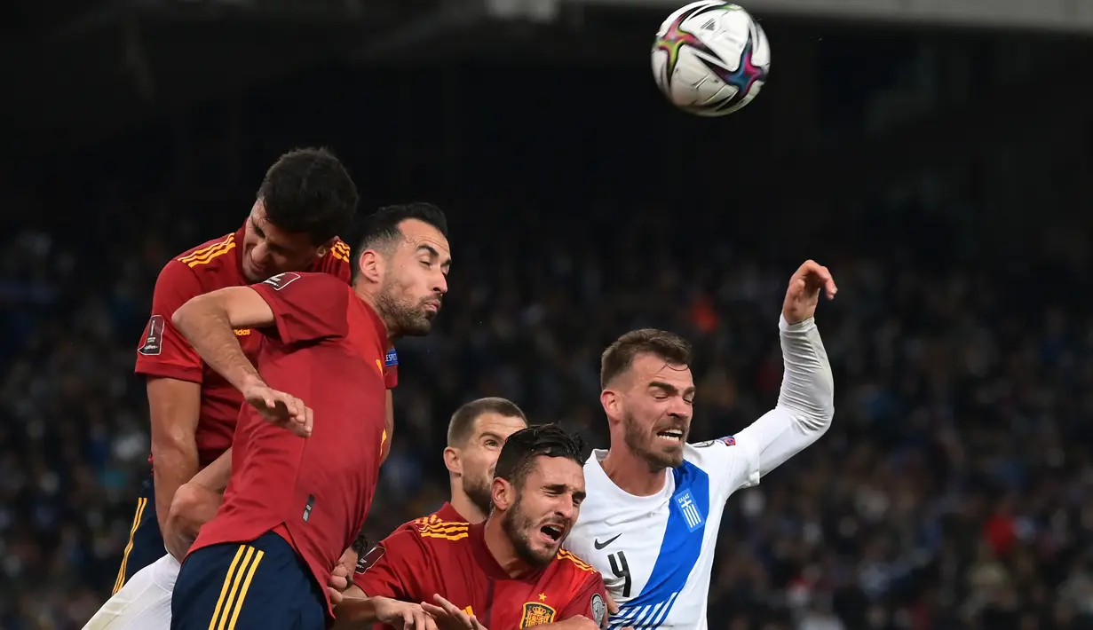 Bek Spanyol Inigo Martinez Berridi (kiri) berebut bola dengan bek Yunani Kyriakos Papadopoulos pada laga Kualifikasi Piala Dunia 2022 zona Eropa Grup B di Olympic stadium, Jumat (12/11/2021) dini hari WIB. Spanyol menaklukkan tuan rumah Yunani dengan skor 1-0. (ARIS MESSINIS/AFP)