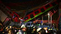 Petugas penyelamat berkumpul di lokasi kecelakaan setelah jembatan layang untuk kereta metro ambruk di Mexico City, Senin (3/5/2021). Rel layang tersebut ambruk saat kereta sedang melintas dan menimpa mobil-mobil di jalan di bawahnya. (Pedro PARDO/AFP)