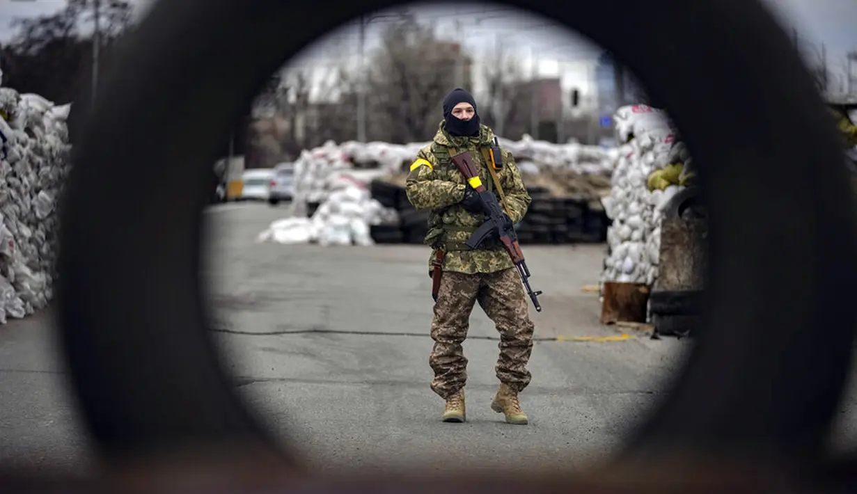 Seorang prajurit Ukraina menjaga pos pemeriksaan di jalan utama di Kyiv, Ukraina, 7 Maret 2022. (AP Photo/Vadim Ghirda)