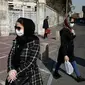 Warga Iran terlihat memakai masker sebagai upaya perlindungan dari Virus Corona yang telah menyebar luas di negara tersebut. (AP/ Vahid Salemi)