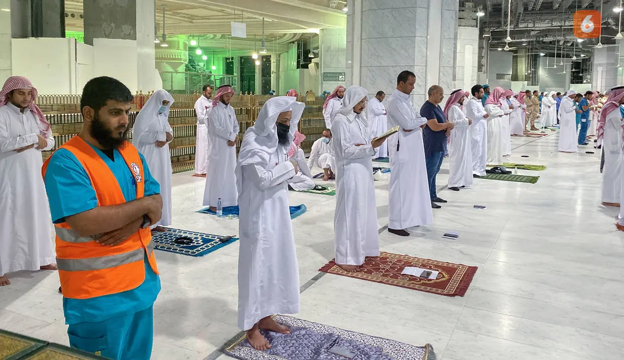 Umat Muslim melaksanakan salat tarawih berjemaah dengan menjaga jarak selama bulan suci Ramadan di Masjidil Haram, Kota Mekkah pada 8 Mei 2020. Otoritas Saudi mengizinkan sejumlah jemaah  memasuki Masjidil Haram untuk melakukan salat selama Ramadan di tengah pandemi virus corona. (STR / AFP)