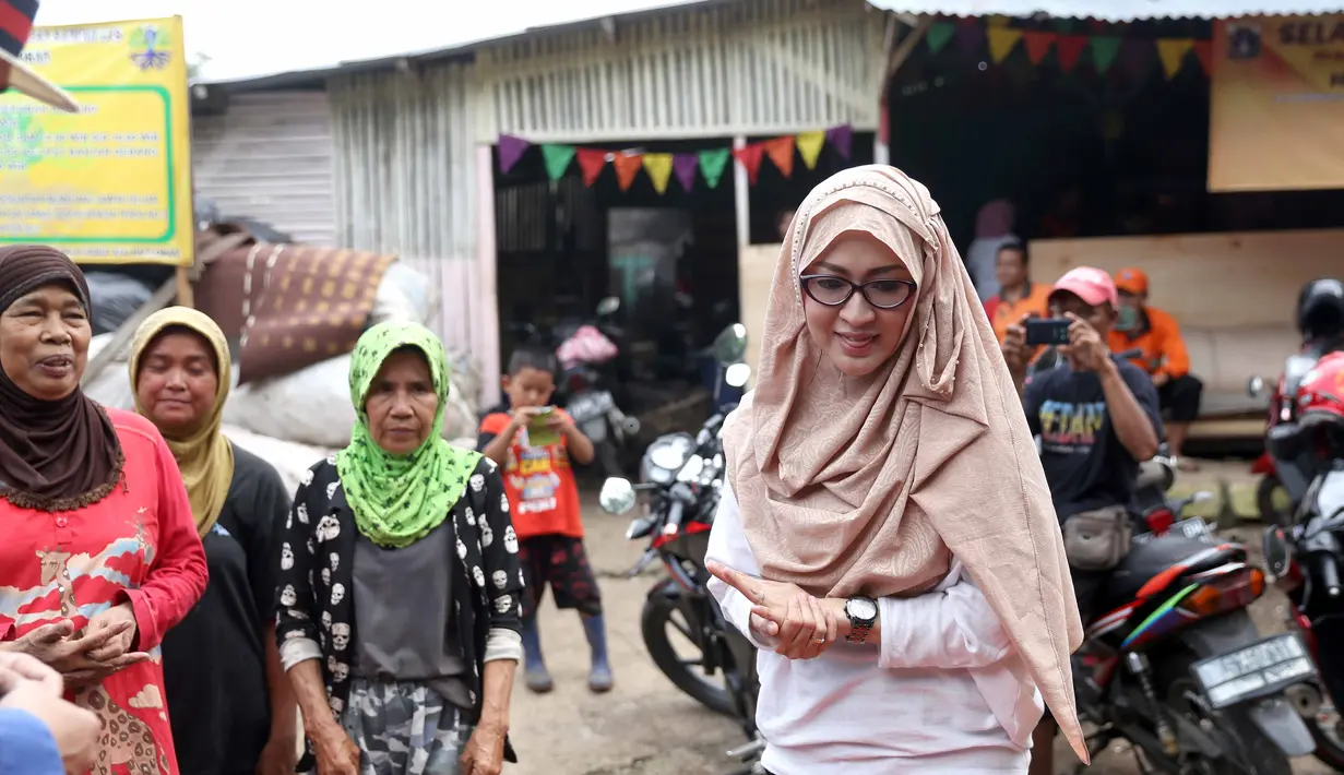 Bersama dengan putrinya, Okie Agustina mengunjungi tempat pembuangan sampah. Ia berharap, kegiatan yang dilakukan setiap bulan itu bisa menumbuhkan jiwa sosial bagi buah hatinya. (Nurwahyunan/Bintang.com)