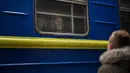 Bogdan, 41, mengucapkan selamat tinggal kepada istrinya Lena, 35, di kereta api menuju Lviv di stasiun Kiev, Ukraina, 3 Maret 2022. Bogdan tinggal untuk mempertahankan negaranya sementara keluarganya meninggalkan Ukraina mencari perlindungan di negara- negara tetangga. (AP Photo/Emilio Morenatti)