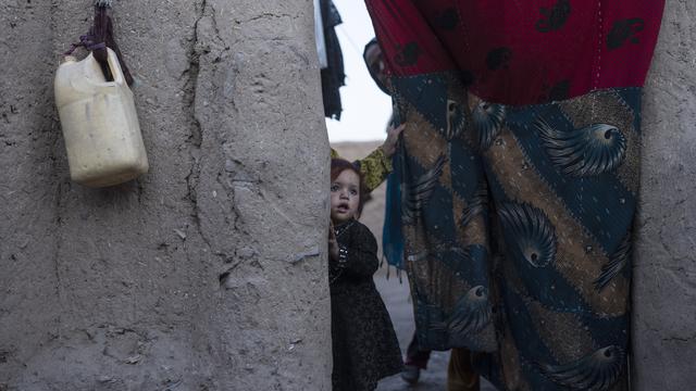 <span>Seorang gadis Afghanistan melihat keluar dari rumahnya di pinggiran Herat, Afghanistan (29/11/2021). Sekitar 2000 pengungsi meninggalkan desa Allahyar di provinsi Ghor karena kekeringan dan mencari bantuan dari pemerintah daerah di Herat. (AP Photo/Petros Giannakouris)</span>