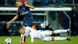 Pemain Real Madrid Casemiro mencoba menghentikan aksi pemain Paris Saint-Germain Kylian Mbappe saat pertandingan Liga Champions leg kedua di stadion Parc des Princes di Paris (6/3). (AP / Francois Mori)