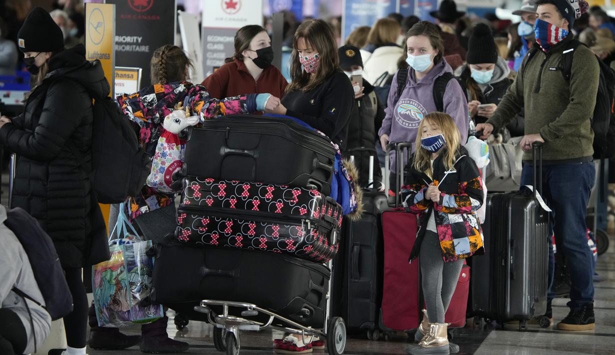 Penumpang mengantre untuk check-in di konter Air Canada di terminal Bandara Internasional Denver di Denver, Senin (3/1/2022). Badai musim dingin ditambah pandemi membuat frustrasi pelancong yang penerbangan pulang dari liburannya dibatalkan atau ditunda di awal tahun. (AP Photo/David Zalubowski)